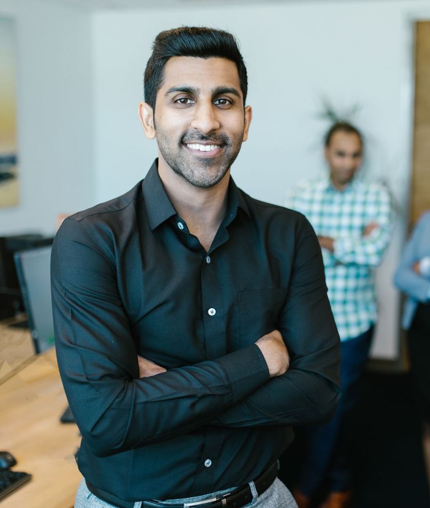 Smiling Indian professional with his team in a modern office