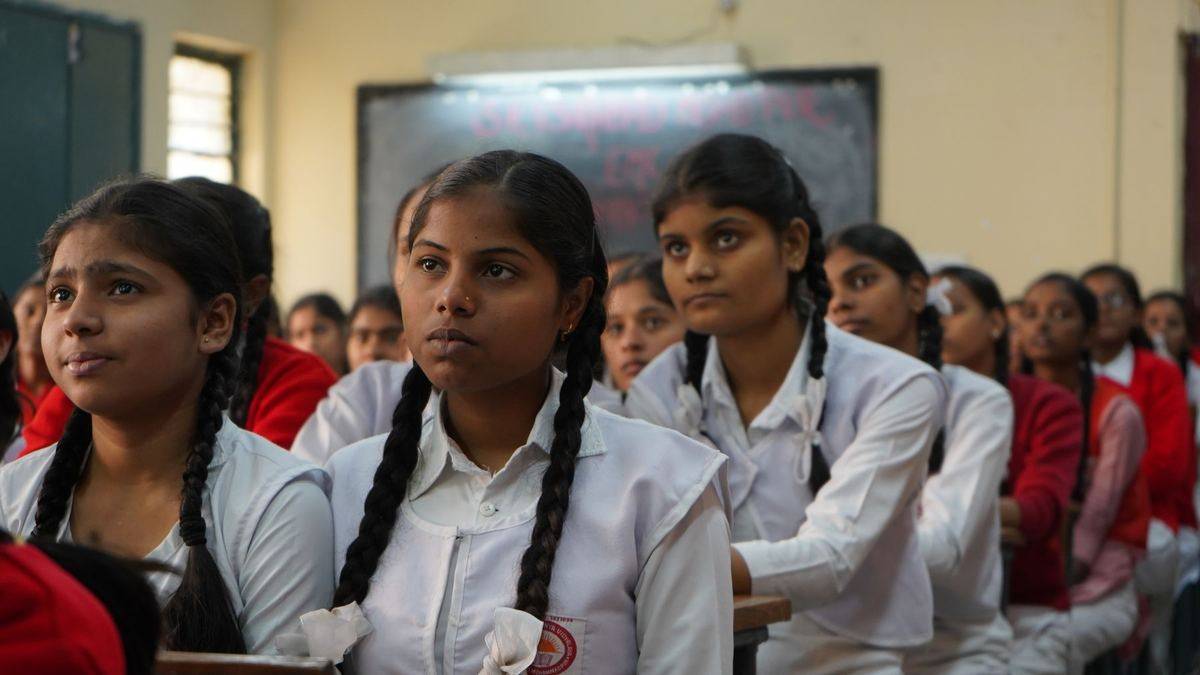 Students in school uniform listening in a classroom