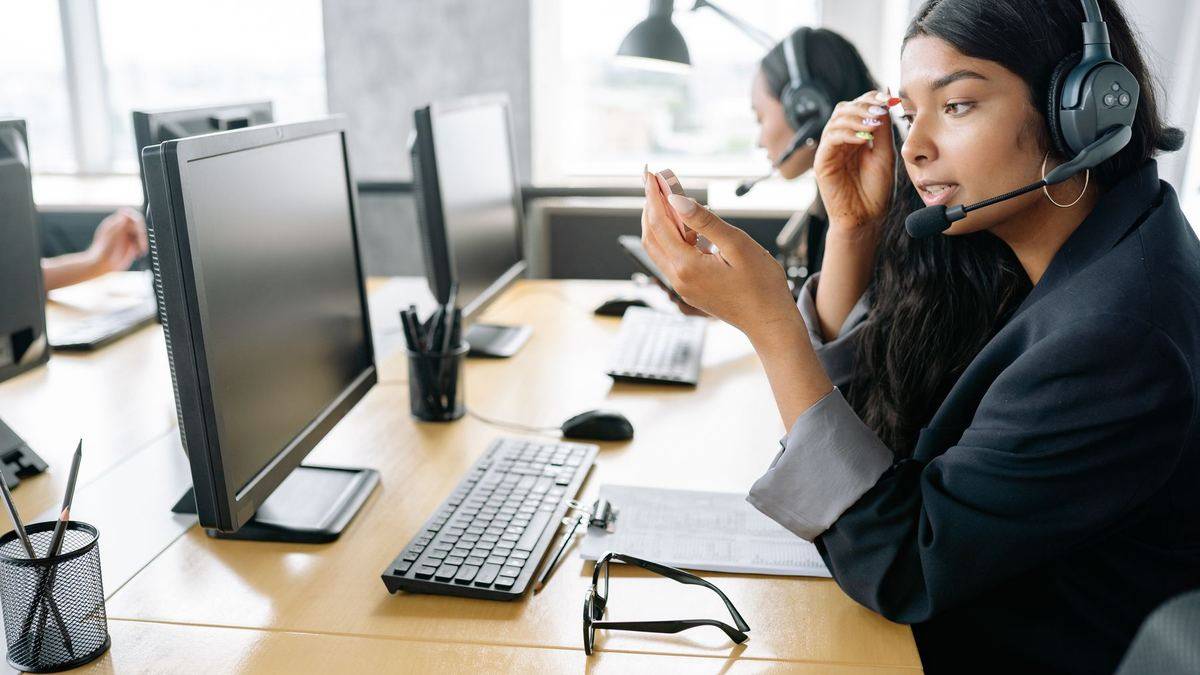 Support agent with a headset at a BPO workstation